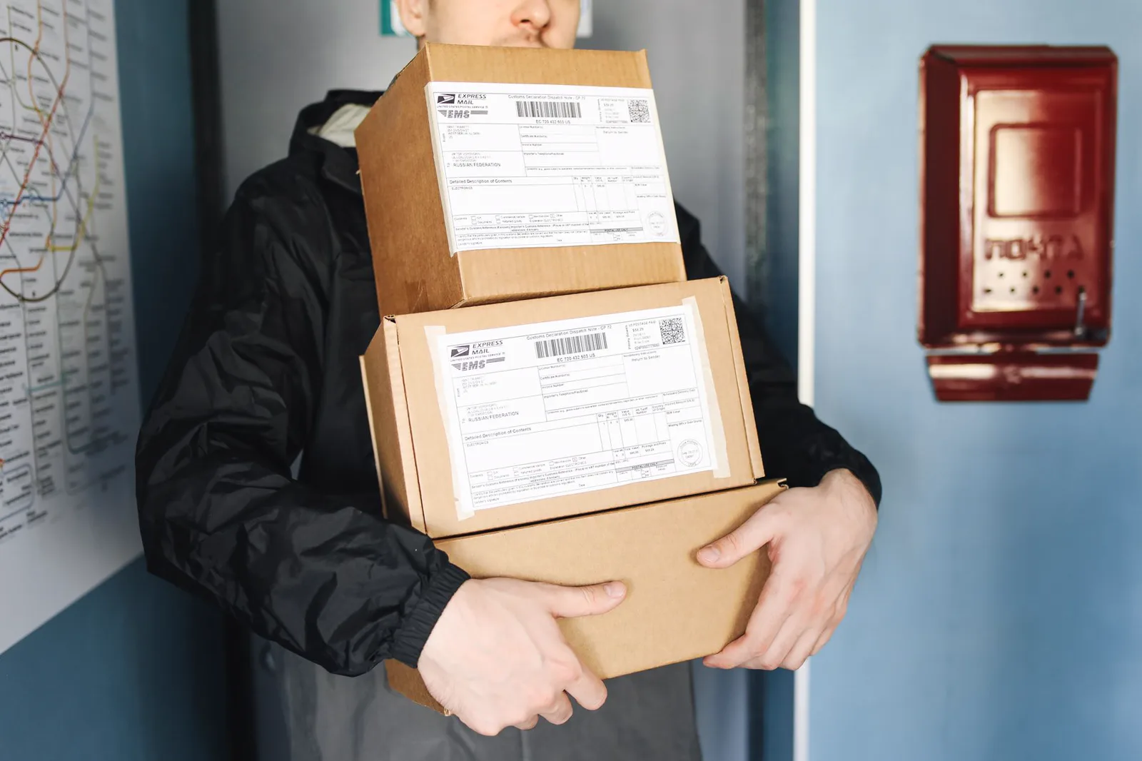 A courier carrying labeled cartons prepared for delivery