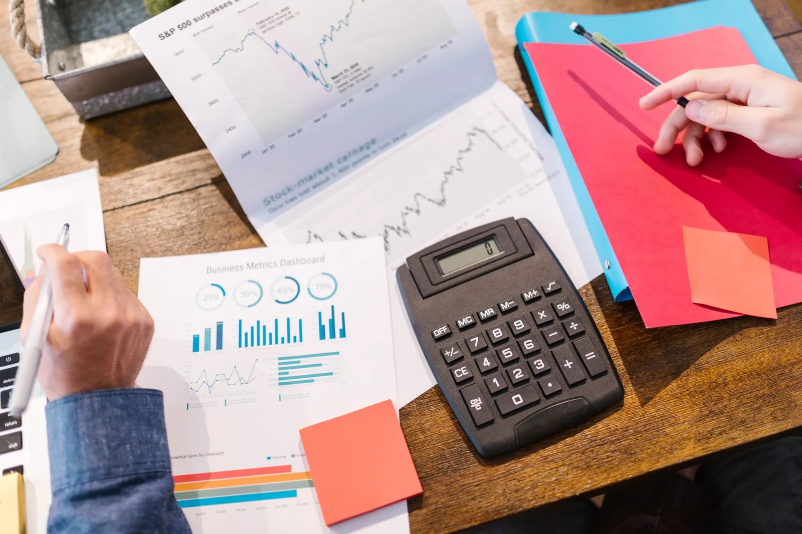Financial documents, charts, and a calculator arranged for comparison