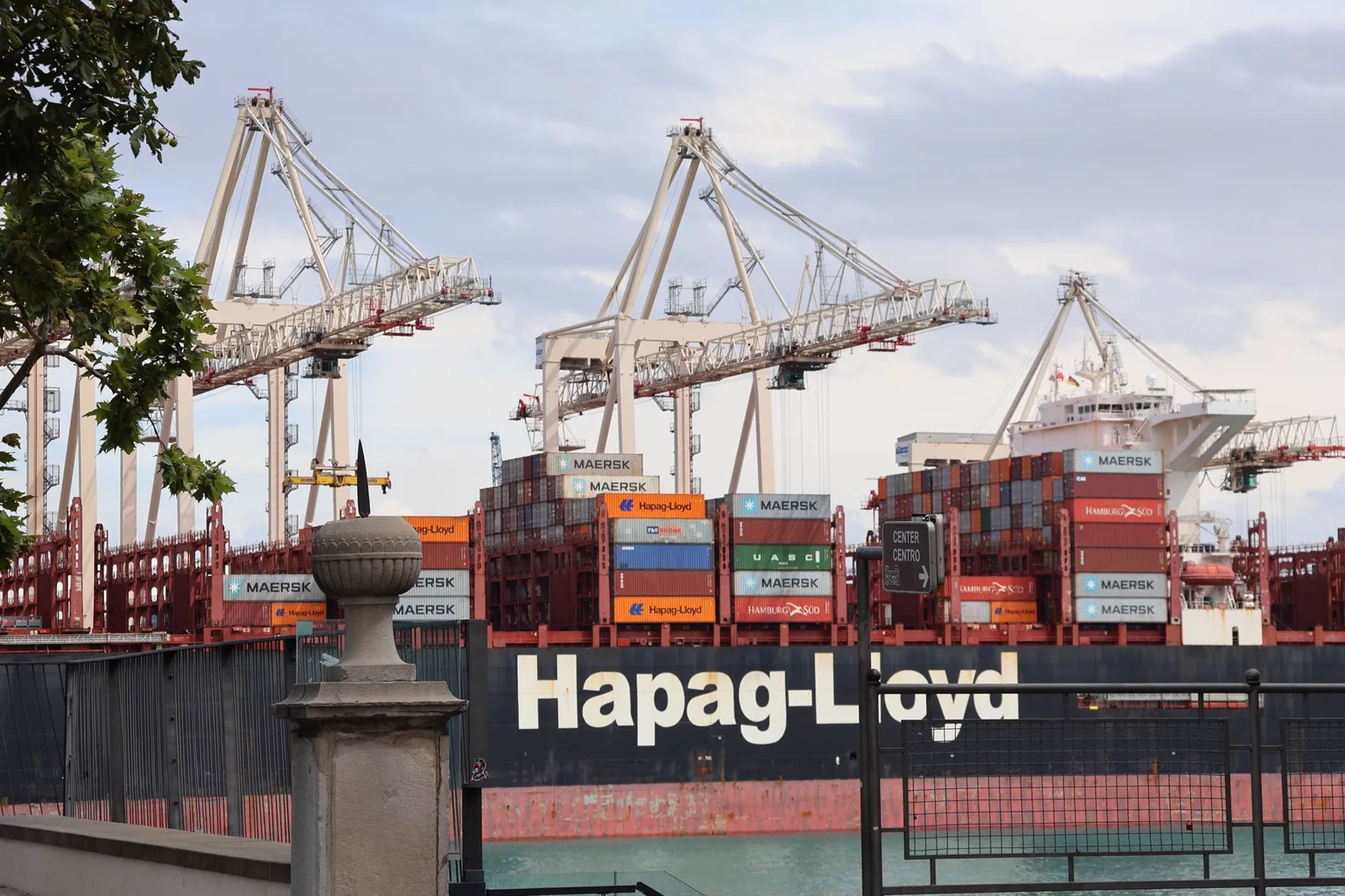A container vessel unloading at a busy industrial port