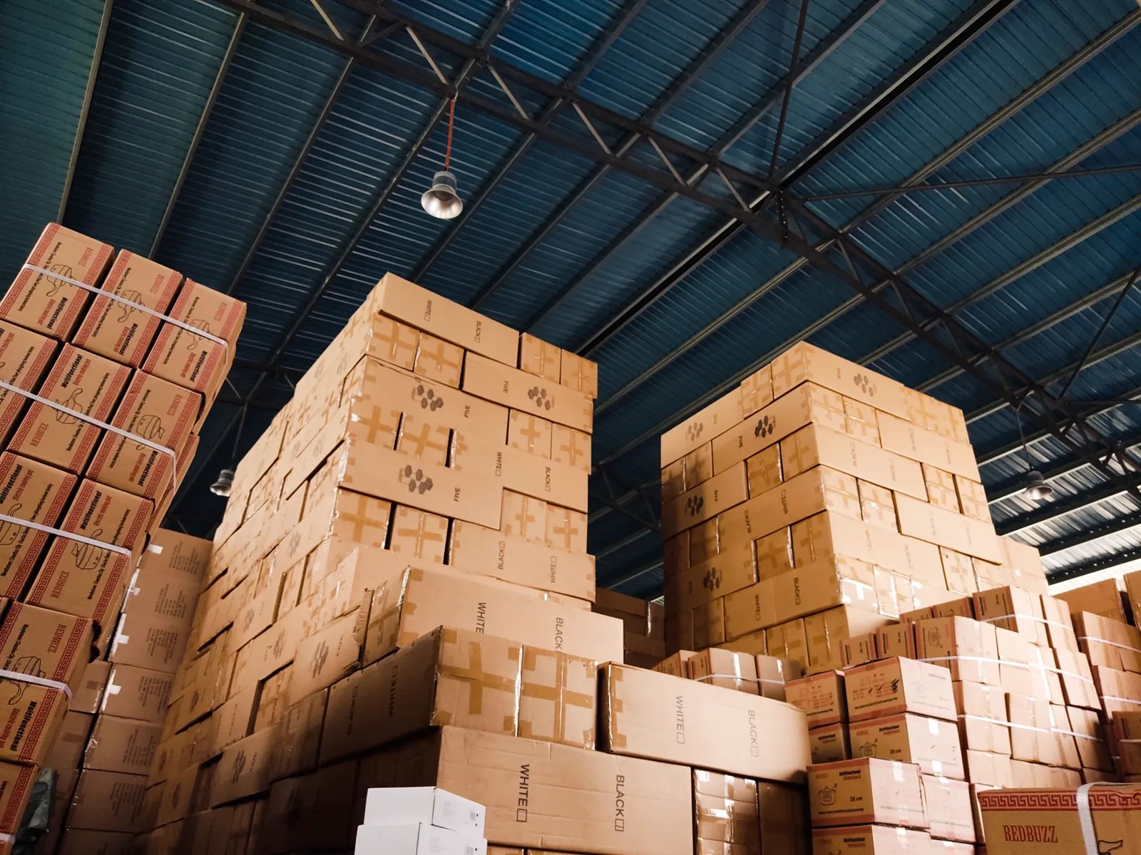 Cardboard boxes stacked inside a large warehouse