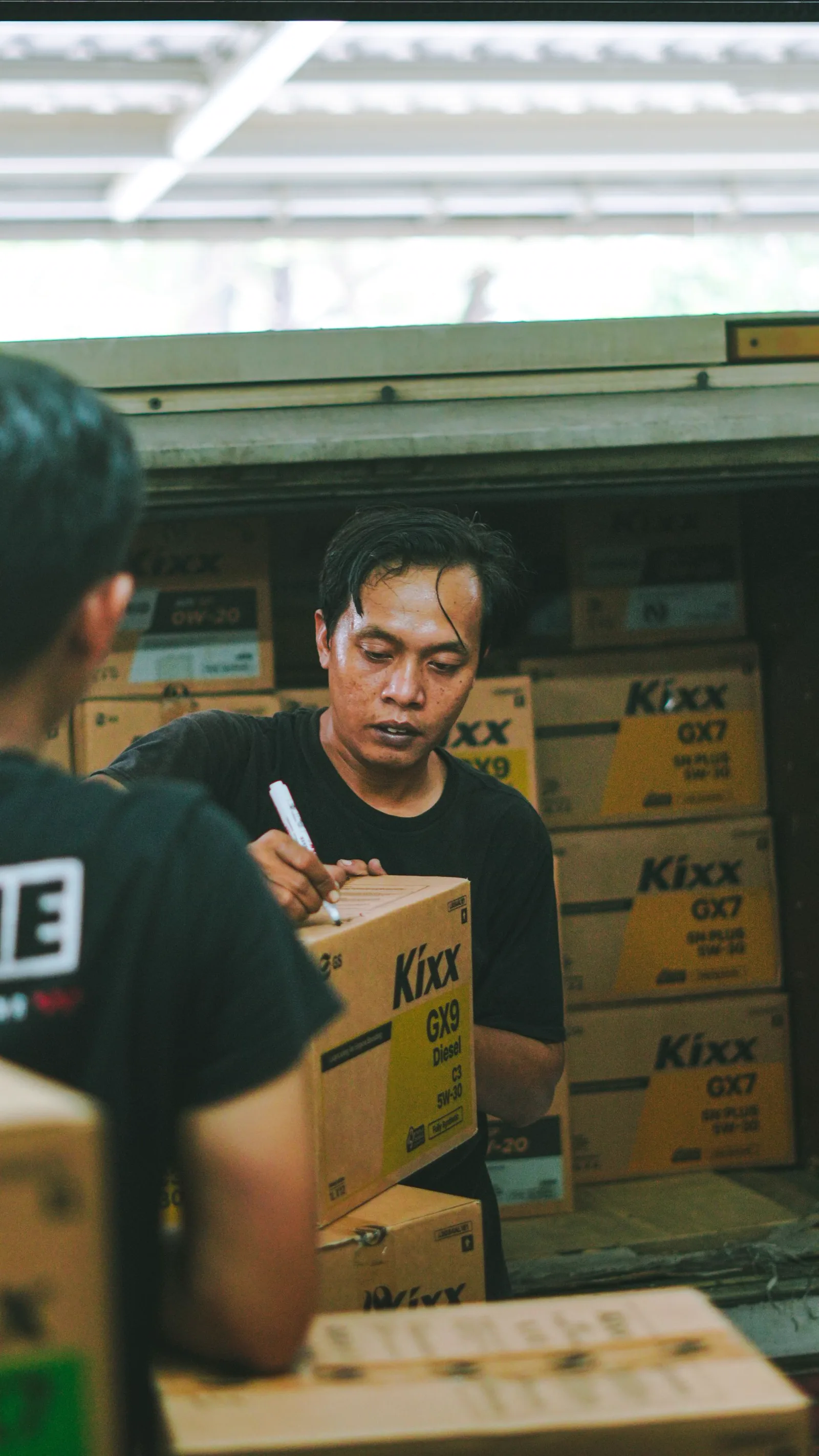 Warehouse workers unloading and organizing cartons for consolidation