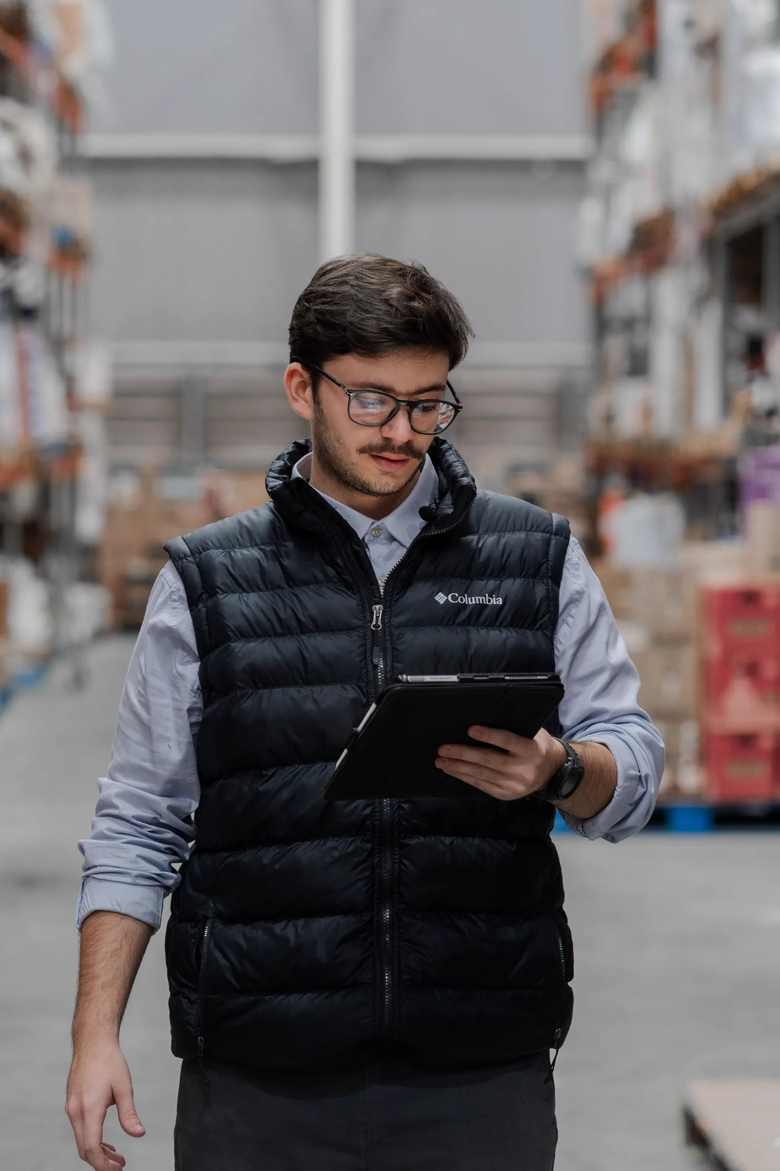 A warehouse worker checking inventory records on a tablet