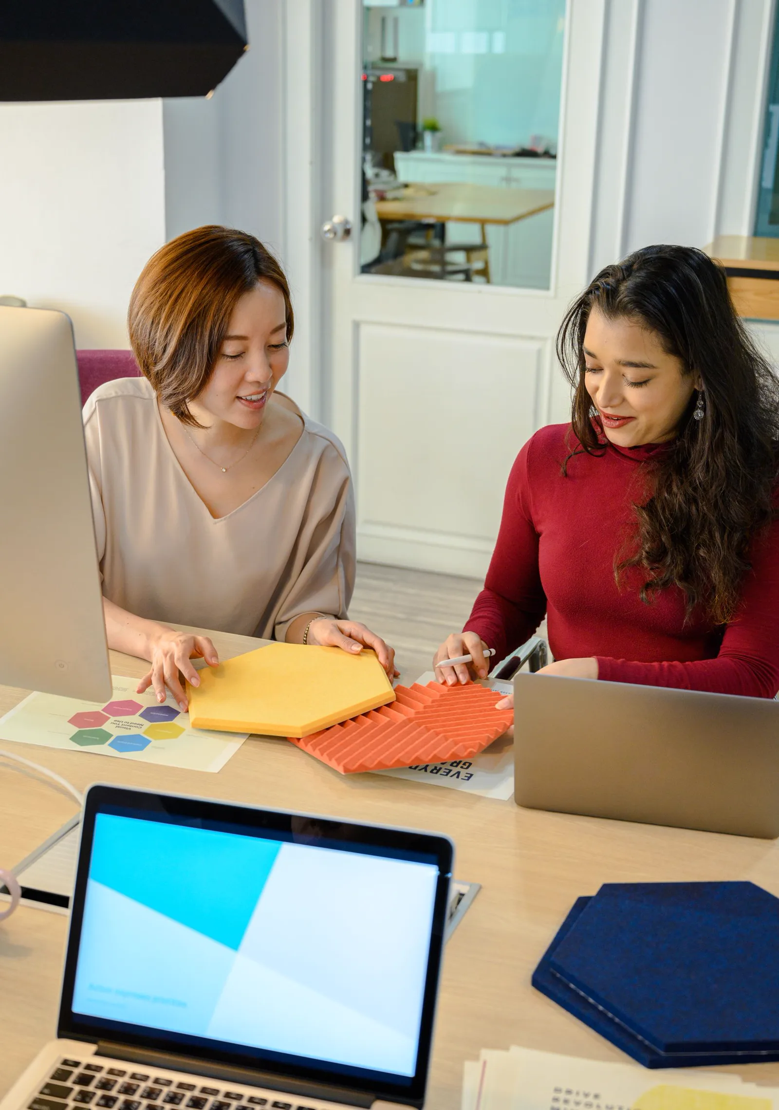 Two professionals reviewing physical product samples during a working session