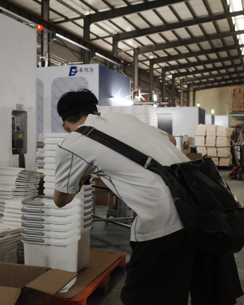 A China-side team member documenting products on a production floor